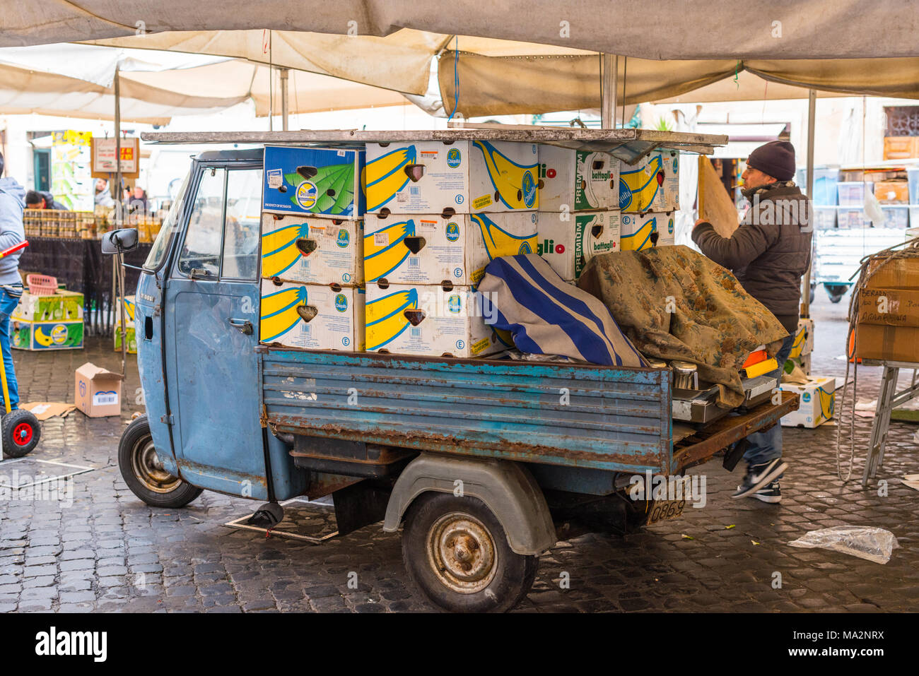 Aufräumen, Verpackung und Verladung Kisten auf einen piaggo Ape 3 wheeler van am Ende des Tages, am Campo de' Fiori, Rom, Latium, Italien. Stockfoto