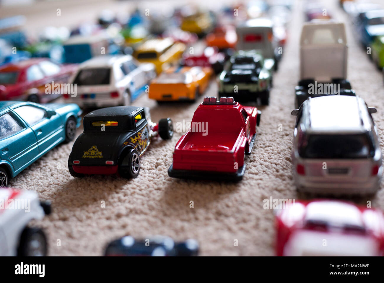 Spielzeugautos aufgereiht auf Teppichboden, England, UK. Stockfoto