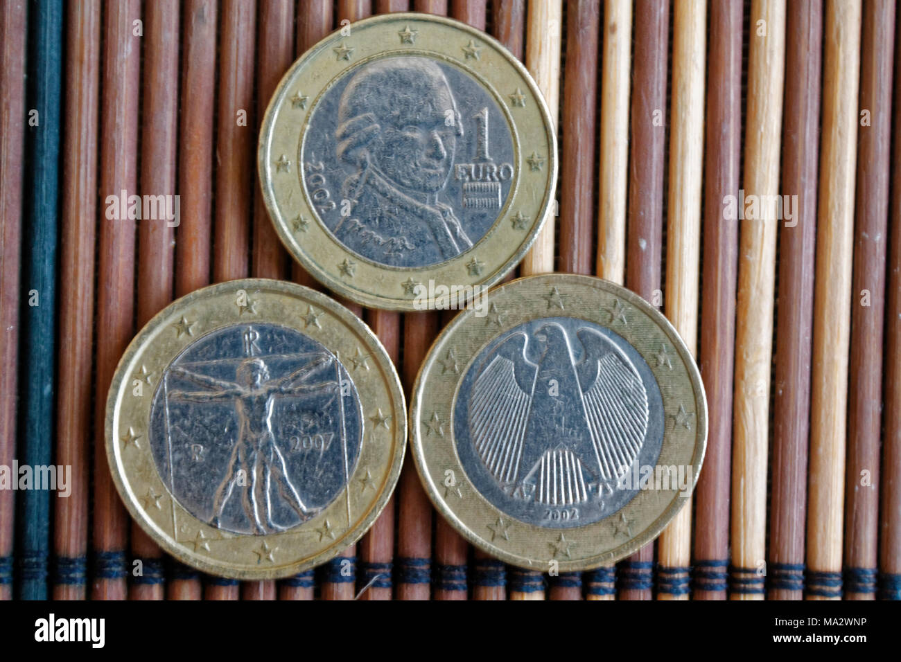 Drei Euro Münzen auf Holz Bambus Tisch liegen in einer Reihe Konfession ist 2 Euro - Rückseite Stockfoto