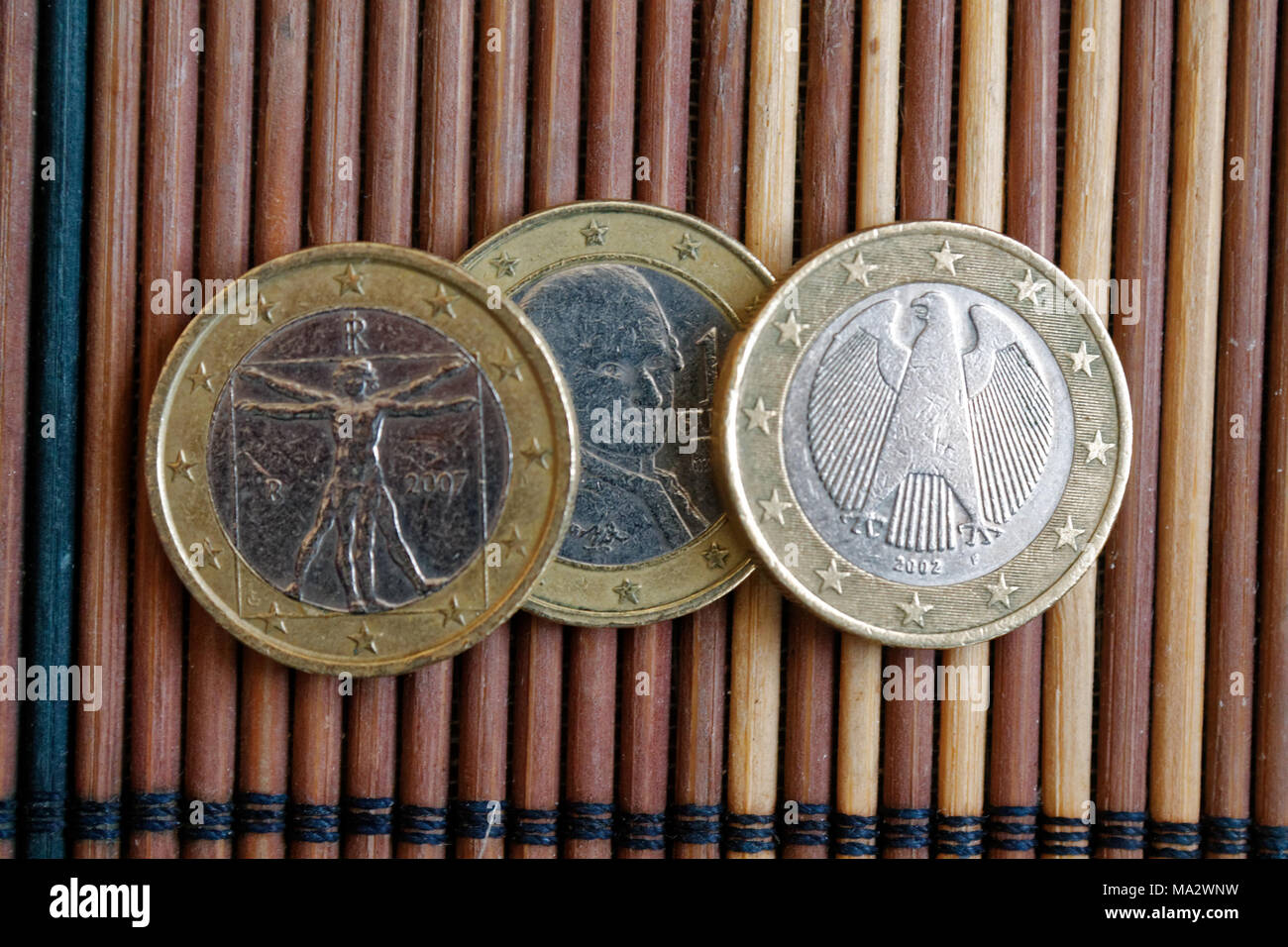 Drei Euro Münzen auf Holz Bambus Tisch liegen in einer Reihe Konfession ist zwei Euro - Rückseite Stockfoto