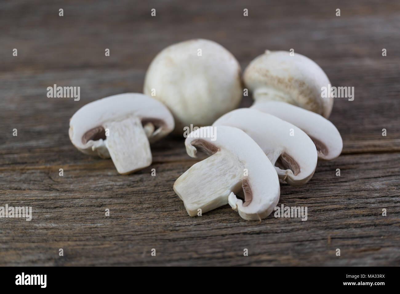 Frische organische champignon Pilze an Holz Hintergrund Stockfoto