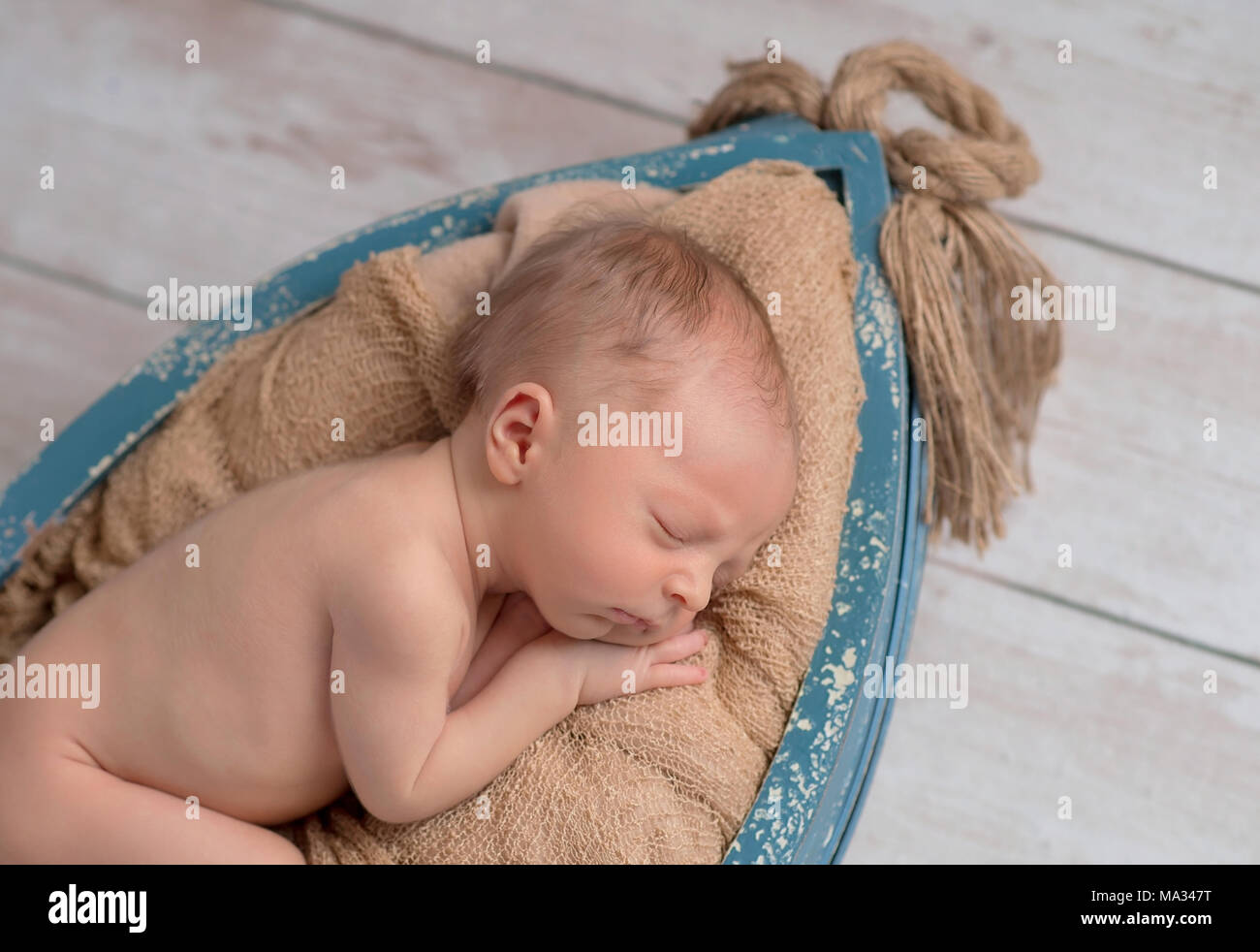 6 Tag alt, neugeborenes Baby schlafen in einem winzigen, hölzernen Boot. Im Studio auf einem Holz Hintergrund gedreht. Stockfoto