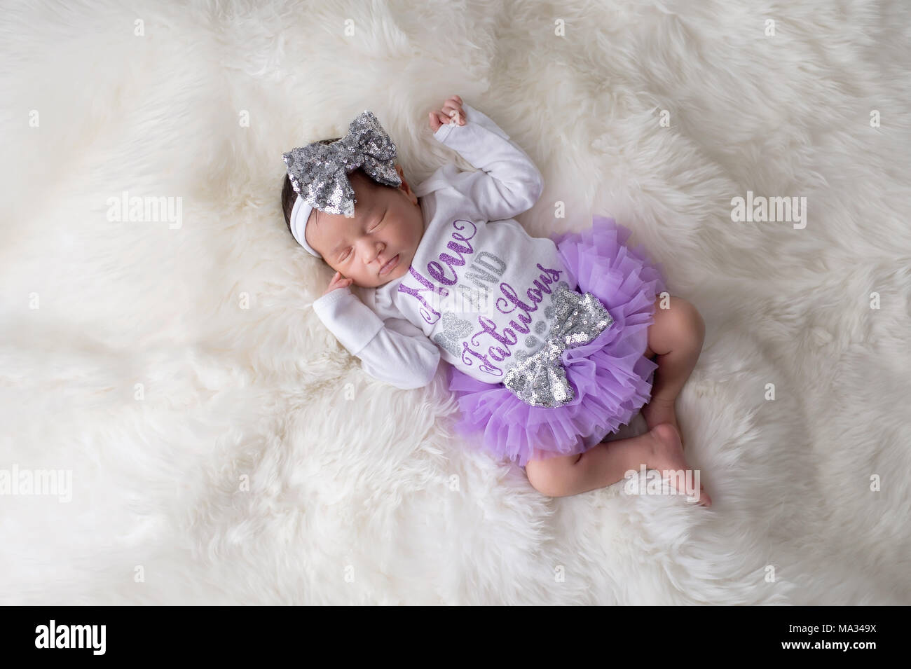 Porträt eines 12 Tage alten Baby girl frilly tragen, Lila, Tutu bloomers und einem weißen Body, die sagen, "Neue und fabelhaft". Im Studio o Shot Stockfoto