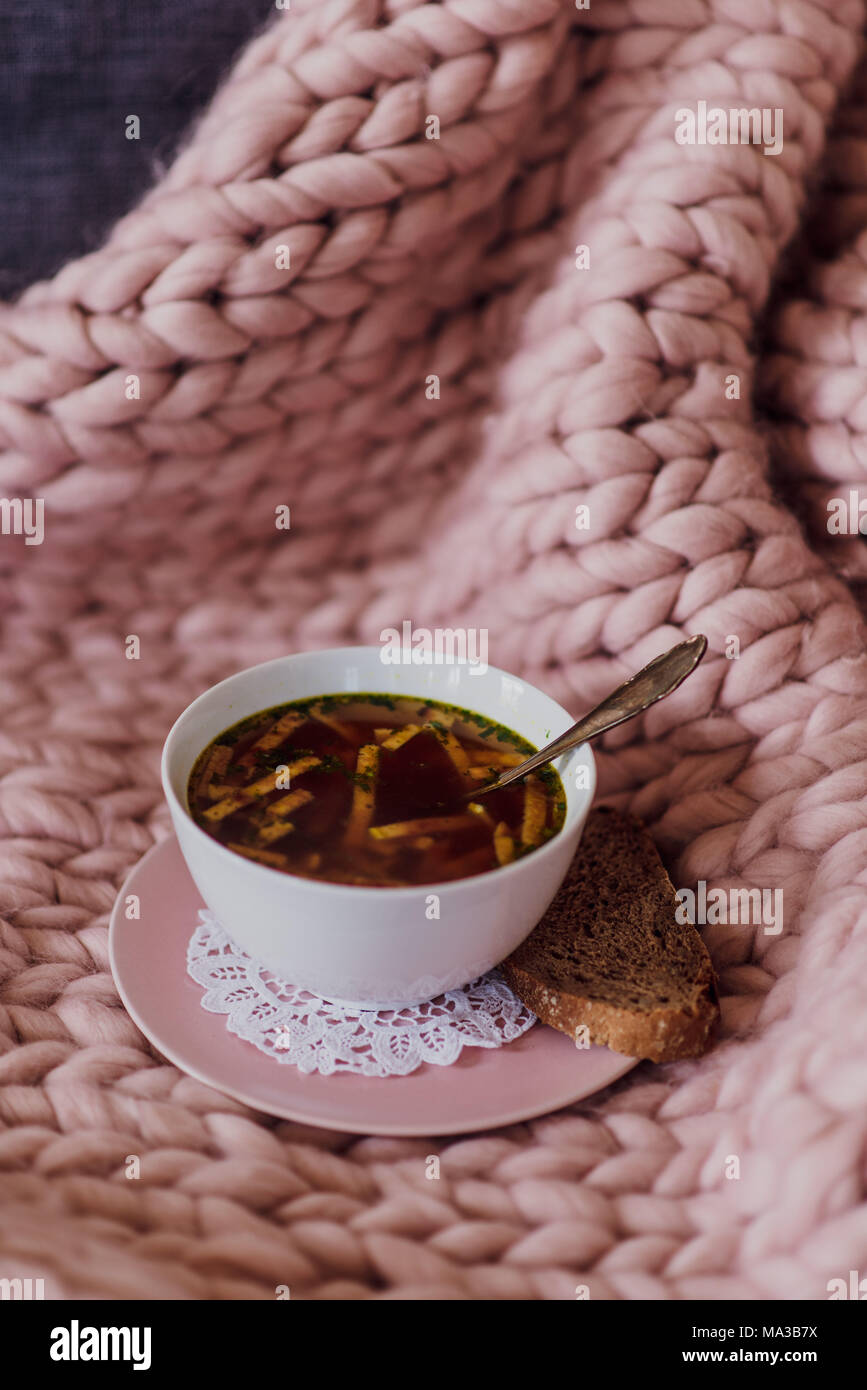 Sofa mit Decke und eine Tasse Suppe, detail, Stockfoto