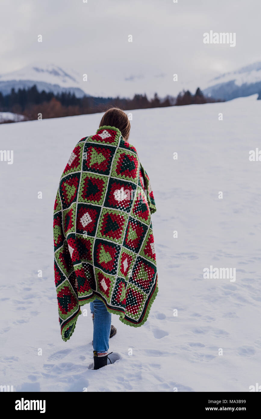 Junge Frau in eine Decke gewickelt ist, stehen im Schnee, Stockfoto