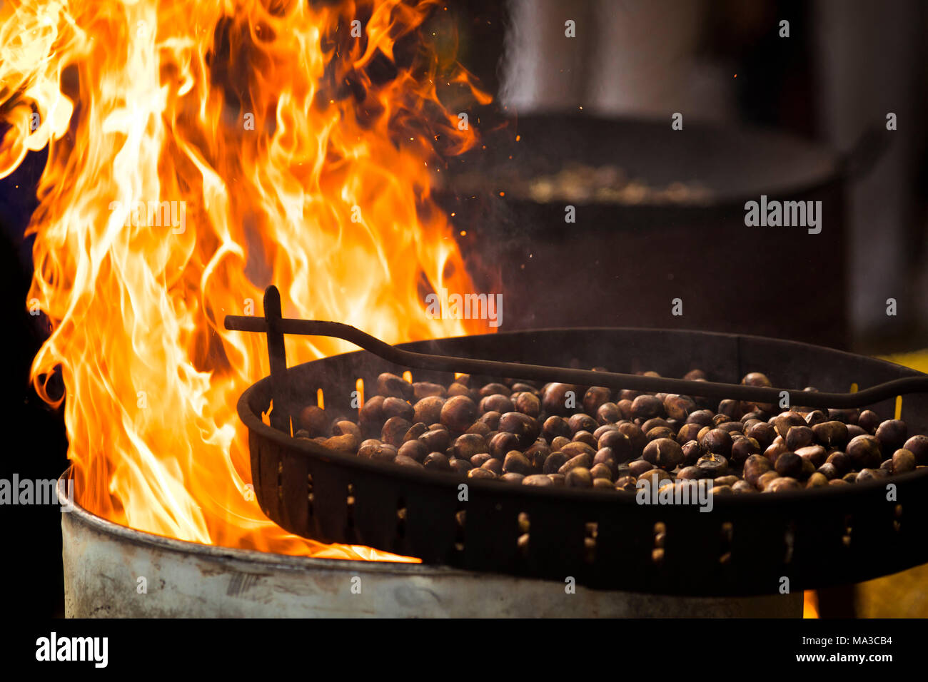 Eine suggestive Snapshot eines kochen Pfanne voller Kastanien rösten durch das Feuer, Provinz Bozen, Südtirol, Trentino Alto Adige, Italien Stockfoto