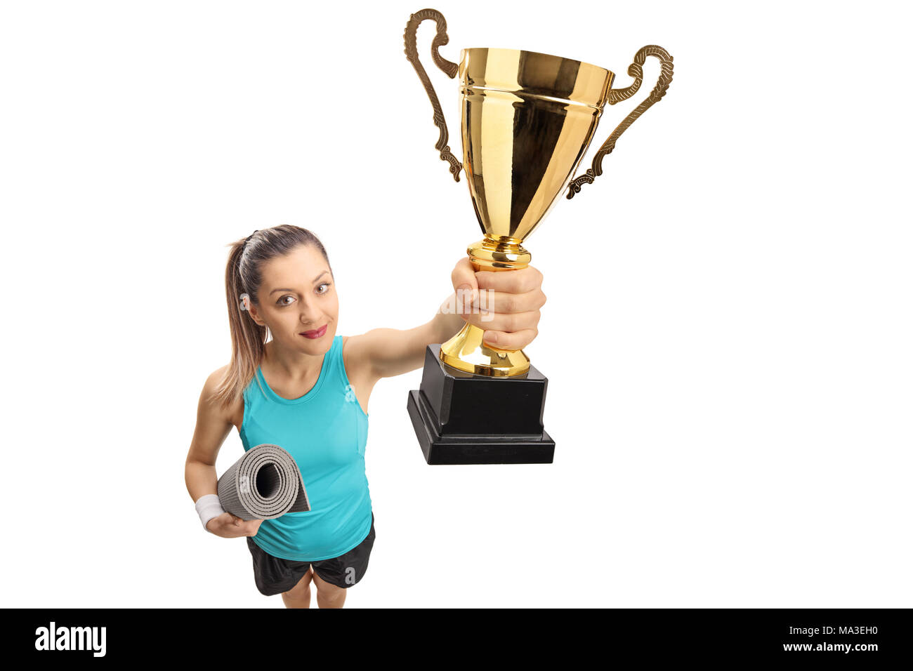 Fitness Mädchen mit einer übung Matte zeigt eine goldene Trophäe auf weißem Hintergrund Stockfoto