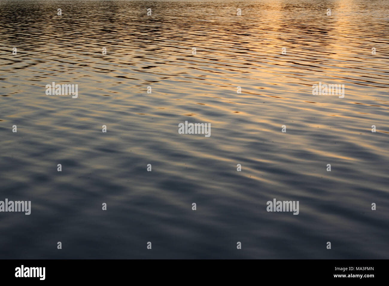 Sanfte Wellen auf reflektierenden Wasseroberfläche Stockfoto