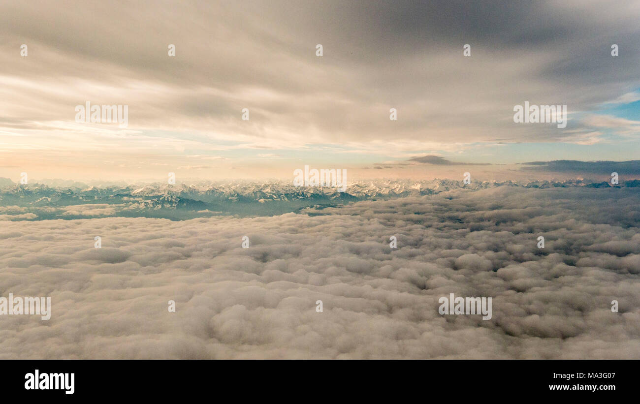 Flug zwischen Cloud Schichten mit Blick auf die Alpen Stockfoto