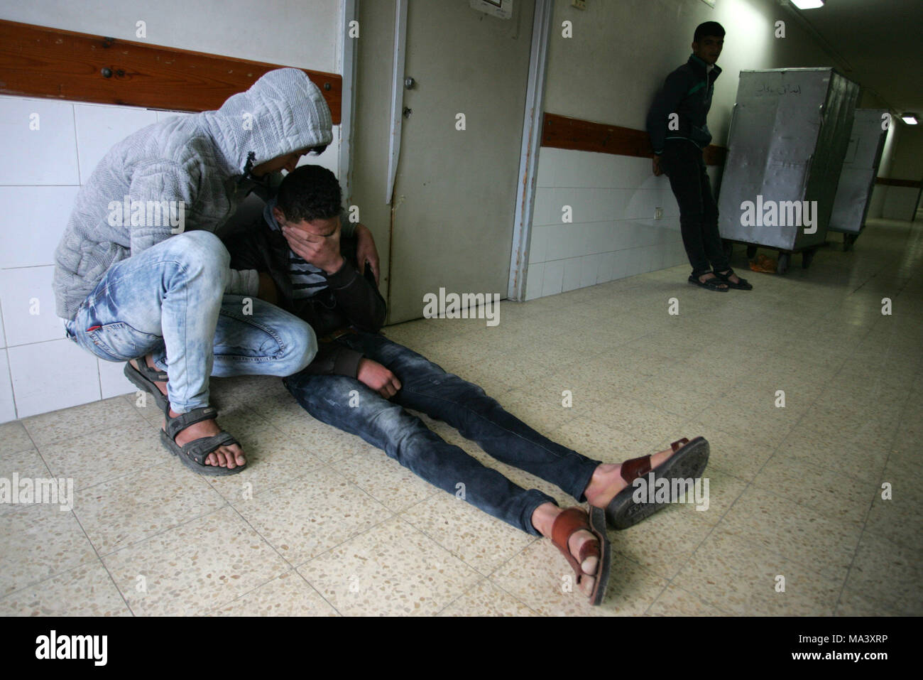 GAZA, palästinensische Gebiete - 30. März, 2018. Die Angehörigen der 27-jährige Palästinensische Bauern Omar Samour, die früher am Tag durch israelische Panzer Feuer getötet wurde, Gebete, wie sie über seinen Körper in der Leichenhalle des Krankenhauses in Khan Yunis im südlichen Gazastreifen Am 30. März 2018 stehen. Lokale Zeugen sagten Samour sein Land war in der Nähe der Grenze zu arbeiten, wenn die Schalen schlagen, während die israelische Armee teilte mit, dass "zwei Verdächtige der Sicherheitszaun entlang der südlichen Gazastreifen angesprochen und wurde misstrauisch. Der Beschuß kam nur wenige Stunden vor der Eröffnung der großen Protest Stockfoto
