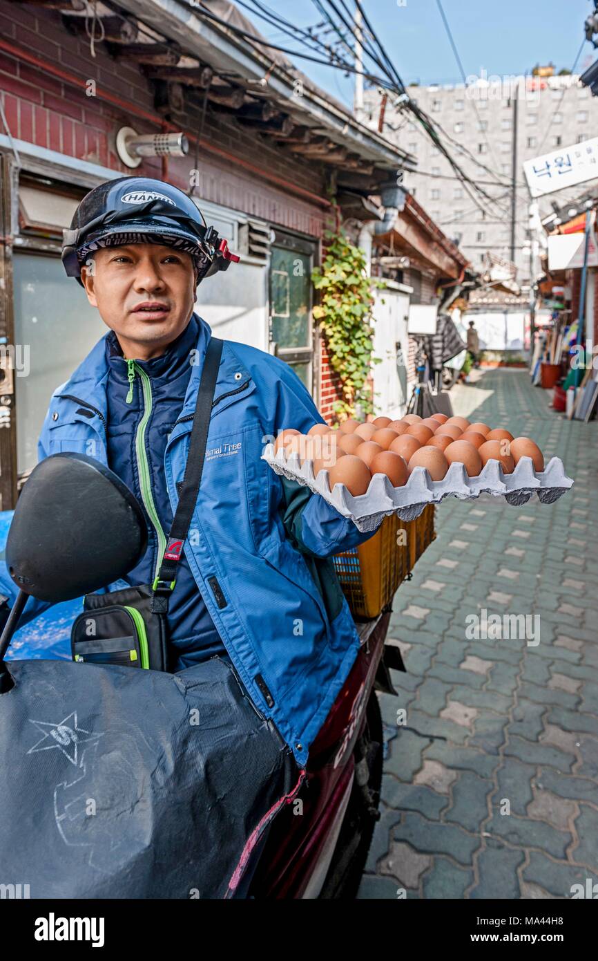 Ein Moped Fahrer mit einem Feld von Eiern in Seoul, Südkorea Stockfoto