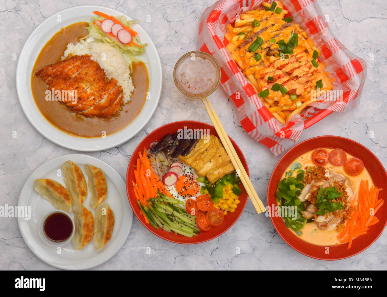 Eine Auswahl von koreanischen Speisen wie Tofu & Pilz Kimchi bimbimbap, Rindfleisch, Hähnchen Red Curry, Gemüse Knödel, knusprige panko Huhn Katsu Curry. Stockfoto