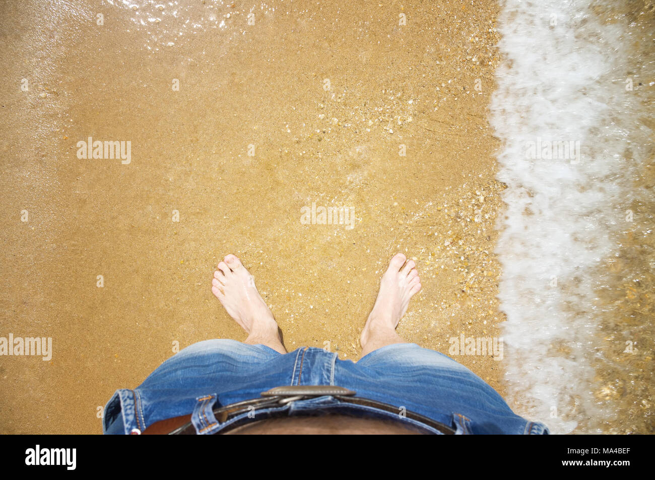 Die Männer die Füße im Wasser am Strand. Der Blick von oben Stockfoto