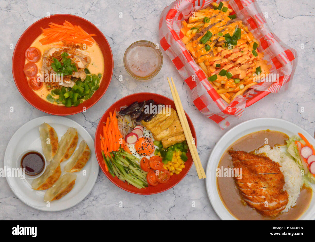 Eine Auswahl von koreanischen Speisen wie Tofu & Pilz Kimchi bimbimbap, Rindfleisch, Hähnchen Red Curry, Gemüse Knödel, knusprige panko Huhn Katsu Curry. Stockfoto