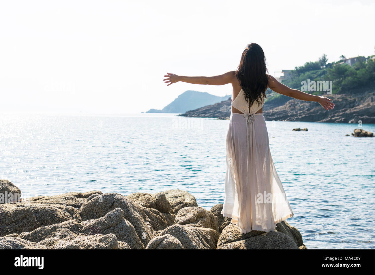 Junge Frau, die sich in der Morgensonne Stockfoto