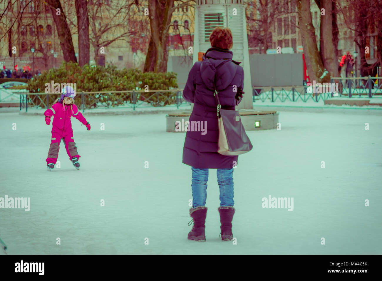 OSLO, Norwegen - 8. MÄRZ 2017: Im freien Blick auf nicht identifizierte Frau mit ihrer Tochter im Schnee spielen in Vigeland Park auf einem windigen Wintertag, vintage Stockfoto
