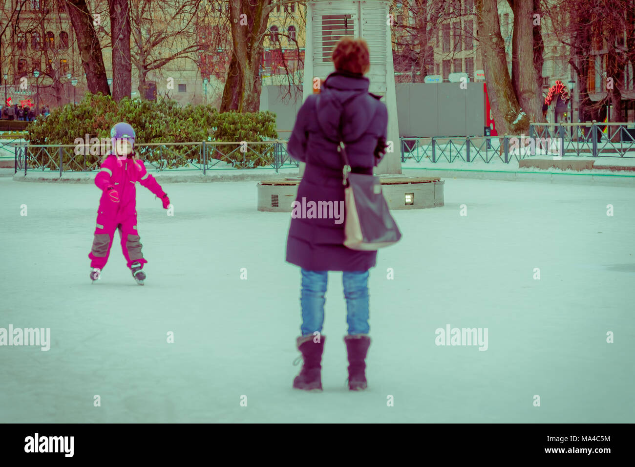 OSLO, Norwegen - 8. MÄRZ 2017: Im freien Blick auf nicht identifizierte Frau mit ihrer Tochter im Schnee spielen in Vigeland Park auf einem windigen Wintertag, vintage Stockfoto