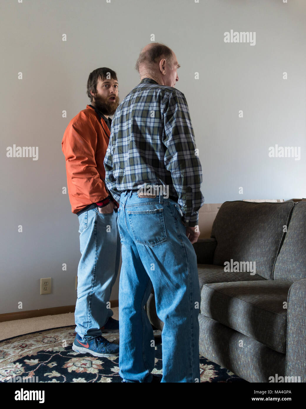 Zwei kaukasische Männer, 20s und eine 80 Jahre alte Senior, Converse, während der junge Mann einen überraschten Ausdruck zeigt. Wichita, Kansas, USA. Stockfoto