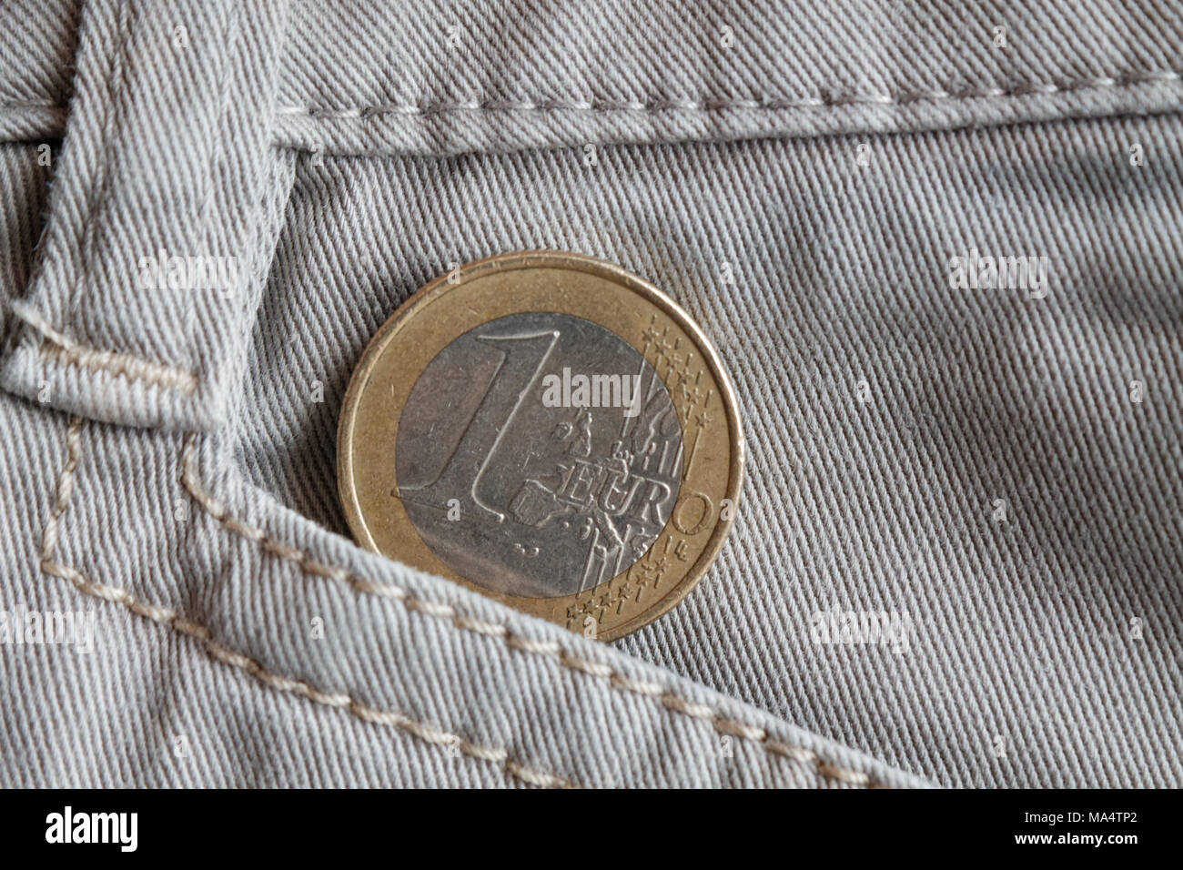 Euro Münze mit einem Nennwert von einem Euro in der Tasche der weißen Jeans Stockfoto