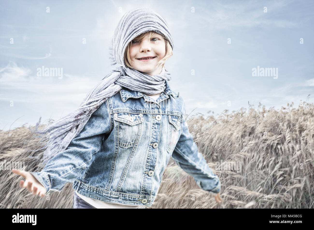 Kleine Mädchen stehen in einem Maisfeld, gegen den Wind Stockfoto
