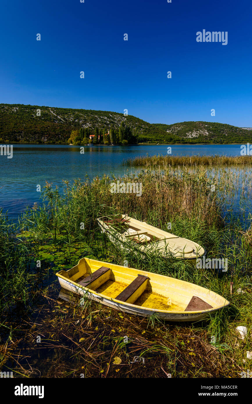 Kroatien, Dalmatien, Region von Sibenik, Krka Nationalpark, Visovac See, Kloster Insel Visovac, Visovac Kloster, Boote im Vordergrund. Stockfoto