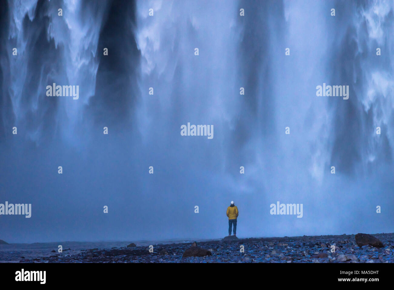 Europa, Nordeuropa, Island, Skógar, Person genießt die sensationelle Spektakel der Wassermassen an Skógafoss Stockfoto
