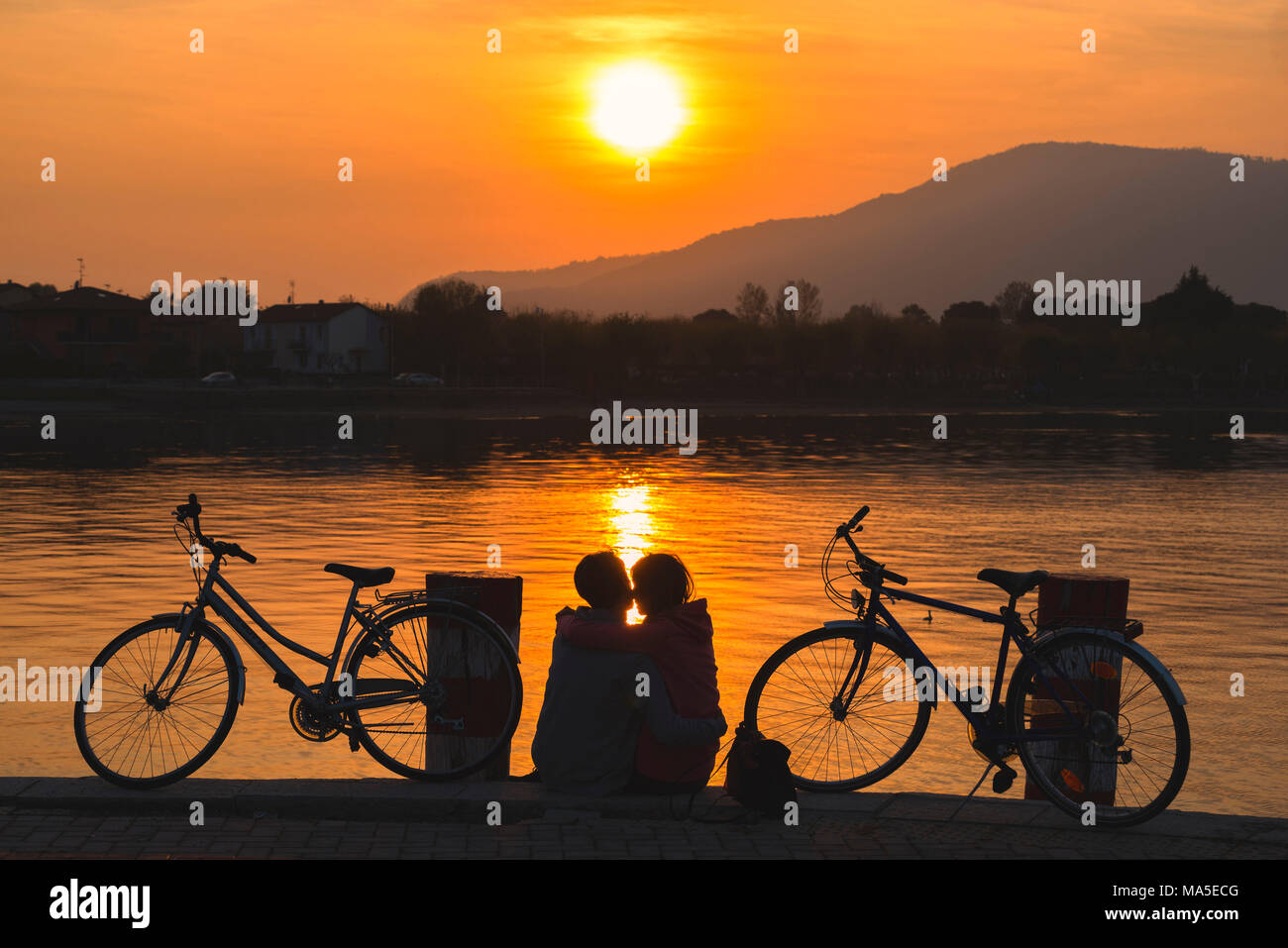 Paar Radfahrer bei Sonnenuntergang, Iseo See, Provinz Brescia, Lombardei, Italien. Stockfoto