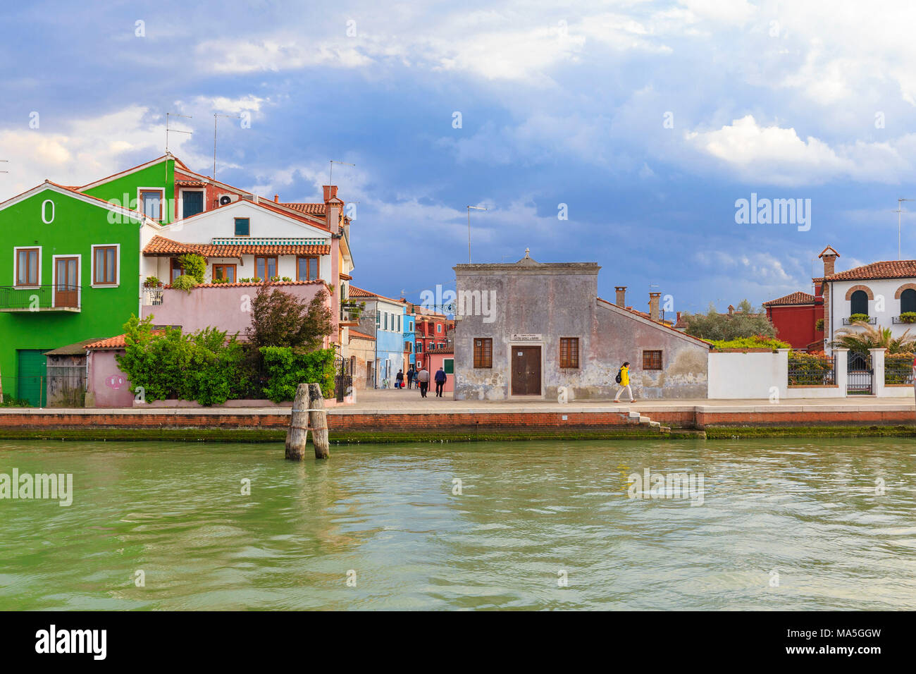 Eine Person Wanderungen entlang eines Kanals von Burano nach dem Gewitter. Burano, Venedig, Venetien, Italien. Stockfoto