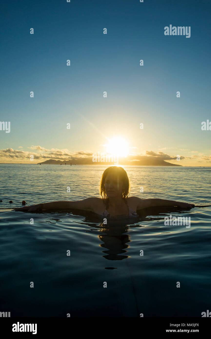 Frau genießen den Sonnenuntergang im Schwimmbad, Papeete, Tahiti, Französisch-Polynesien Stockfoto