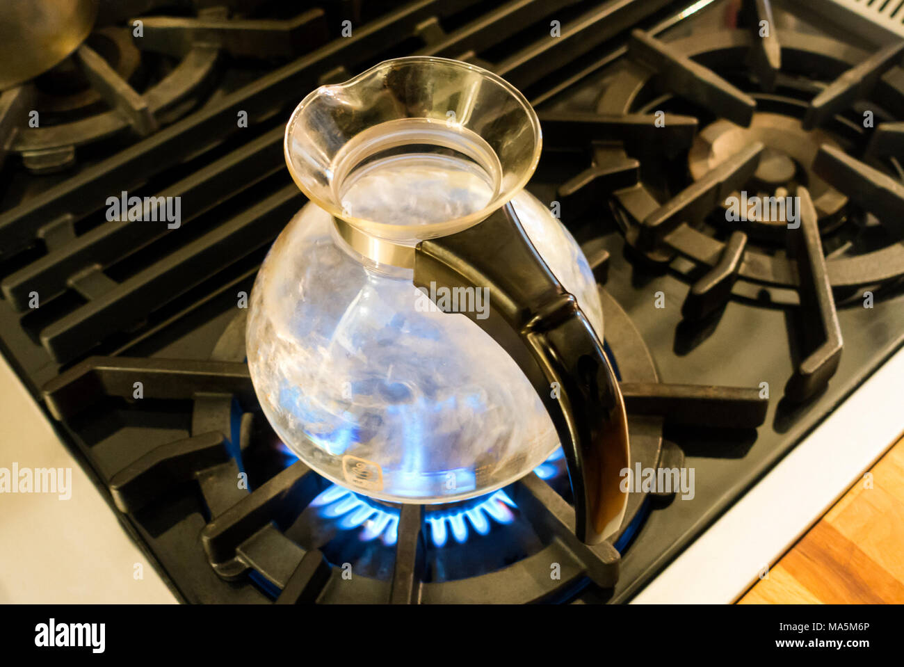 Kochendes Wasser in einem Glas Pfeifen Wasserkocher von Medelco auf eine Herdplatte Stockfoto