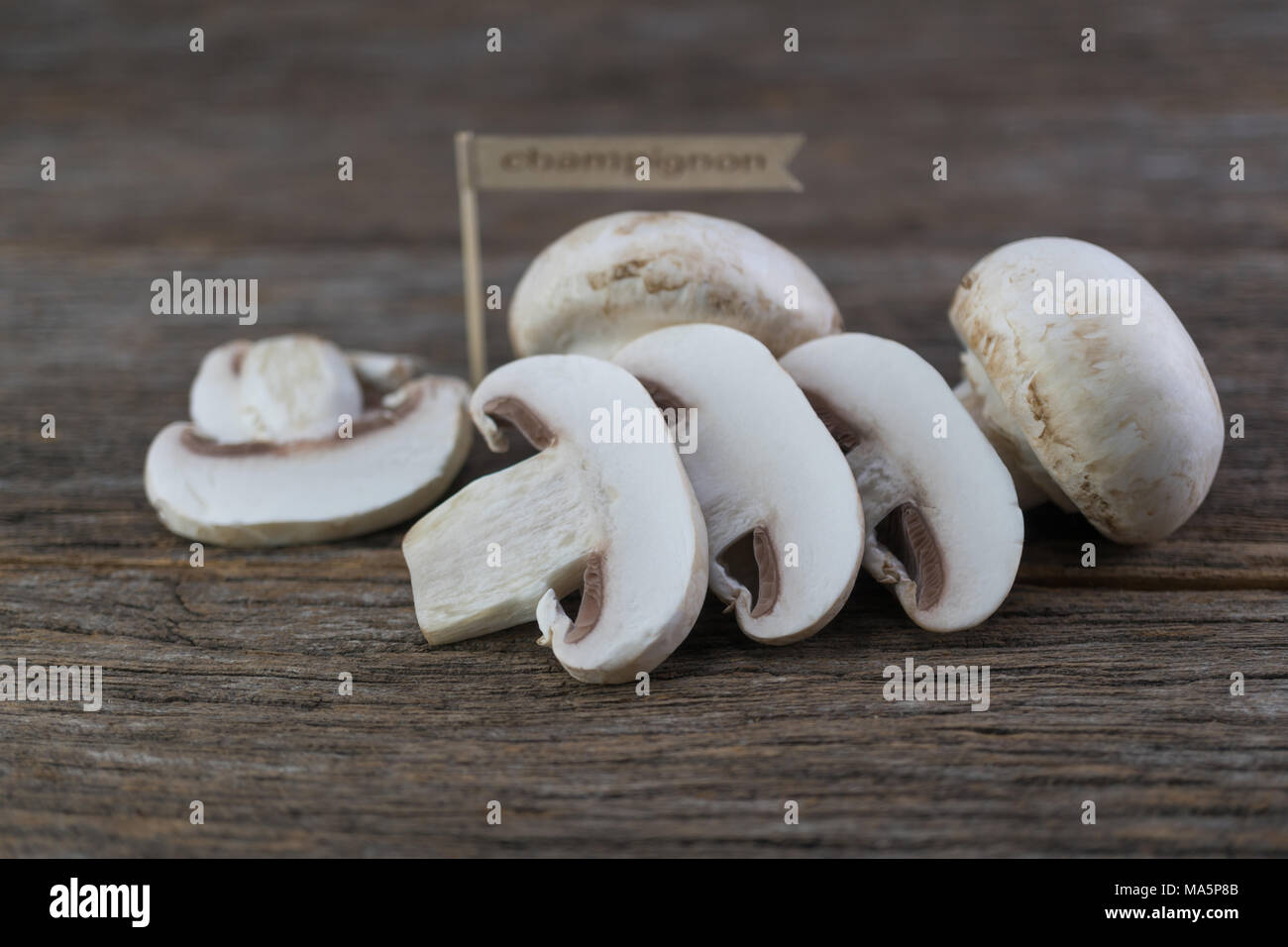 Frische organische champignon Pilze an Holz Hintergrund Stockfoto