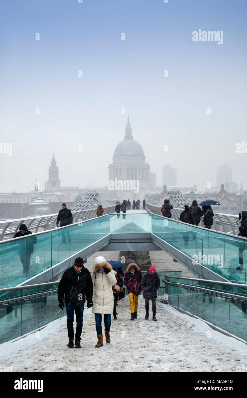 Die Millennium Bridge über die Themse und die Kuppel der St. Paul's Kathedrale in London im Schnee Stockfoto