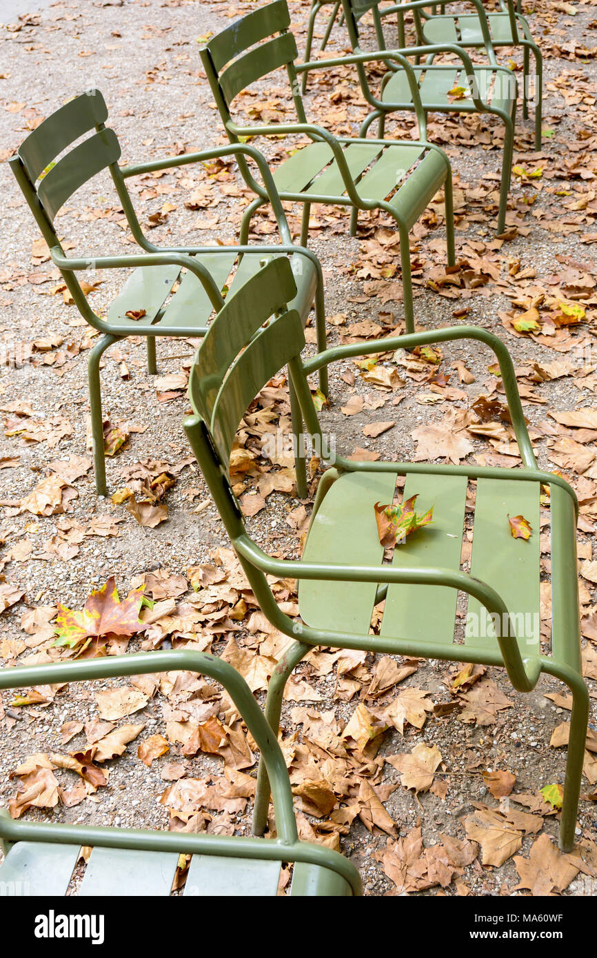 Typische metallische Stühle der öffentlichen Gärten von Paris mit verwelkten Blättern Anfang am Ende des Sommers zu fallen. Stockfoto