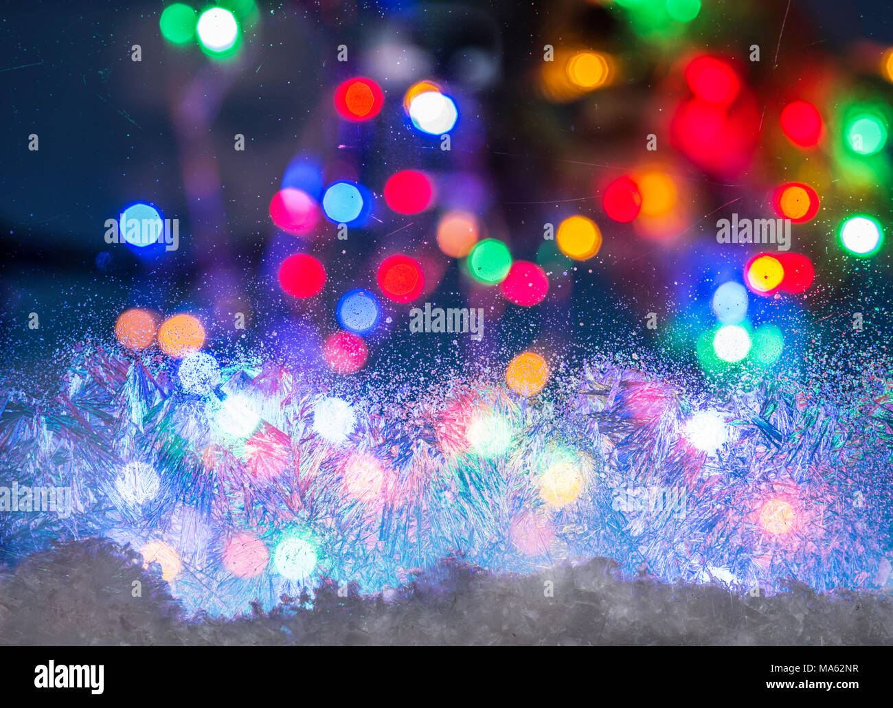 Fenster mit unscharfen farbigen Lichtern im Hintergrund eingefroren. Stockfoto