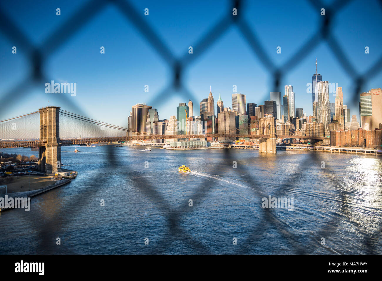 Brooklyn Bridge und Manhattan downtown durch den Zaun, New York City Stockfoto