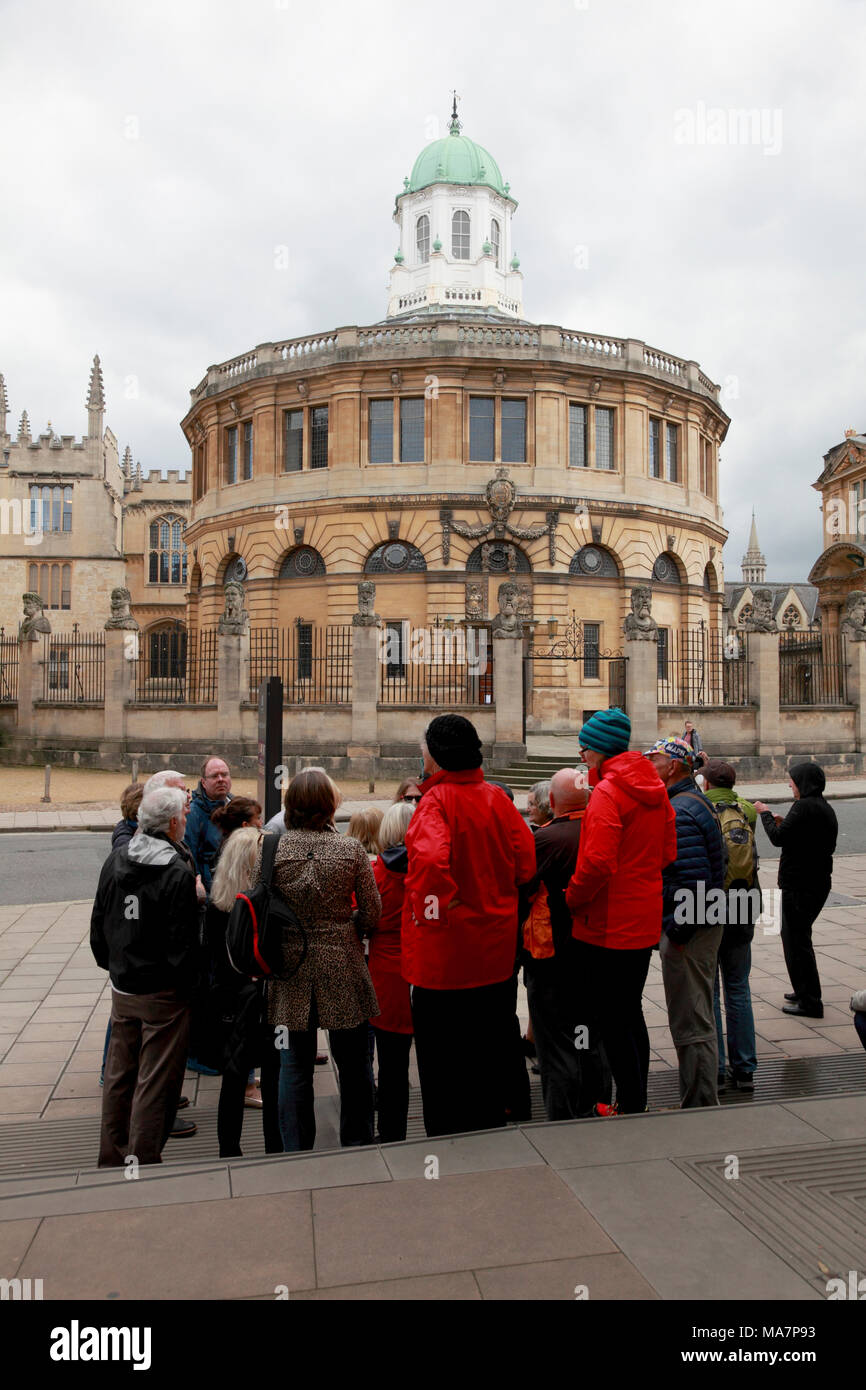 Eine Gruppe von Touristen durch eine Führung vor den Sheldonian Theatre in Oxford angesprochen werden Stockfoto