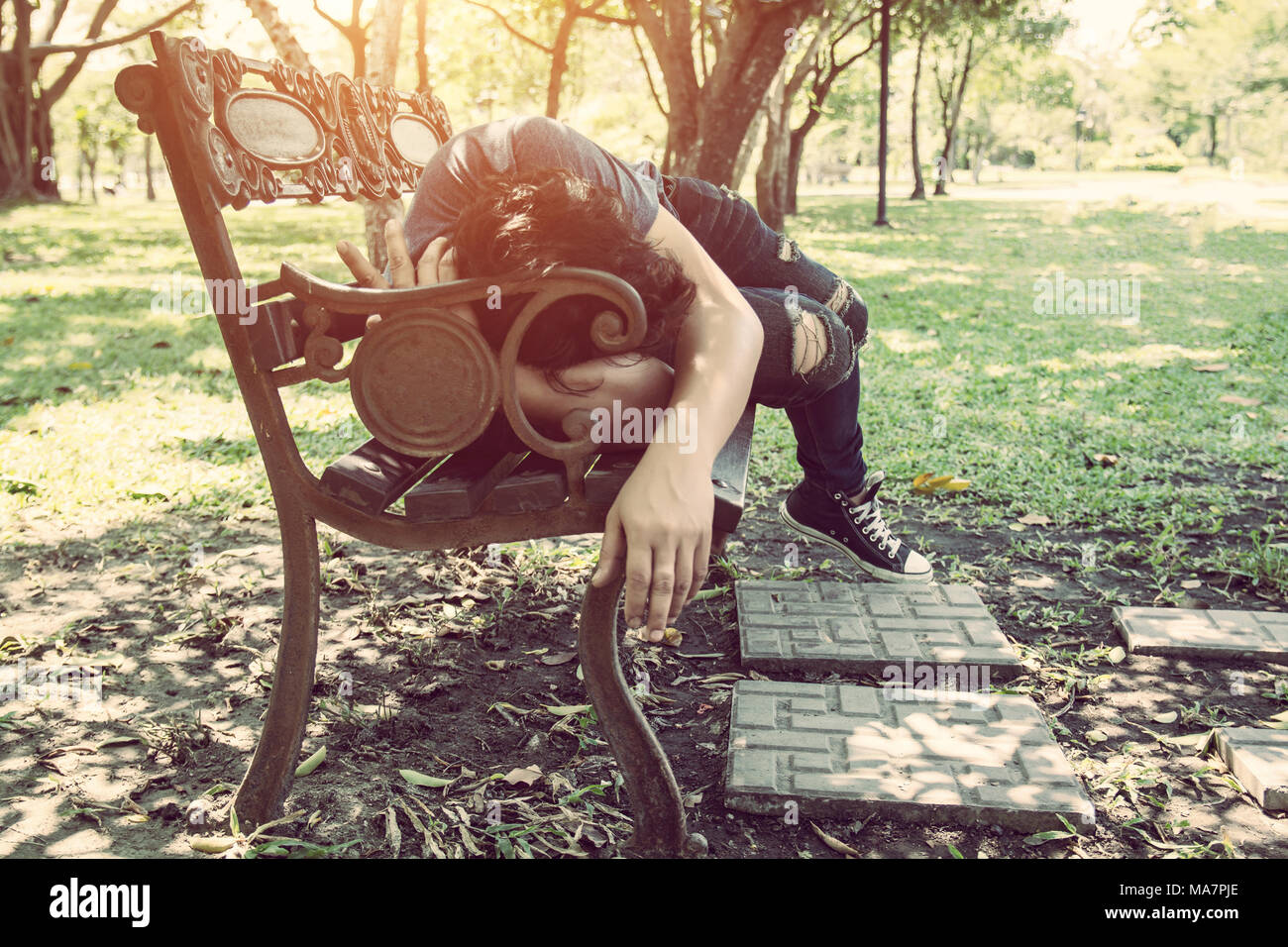 Junger Mann schlafen auf der Werkbank outdoor im City Park während des Tages Stockfoto