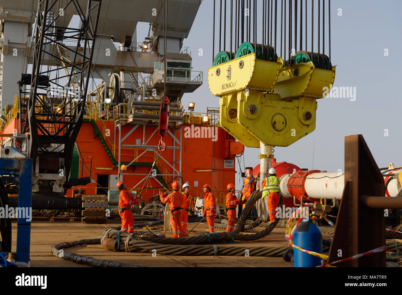 Offshore Bauarbeiter auf dem Deck des DBA (Derrick Barge Aserbaidschan) bereiten die lift Rigg auf den Haupt-Kran zu installieren. Stockfoto