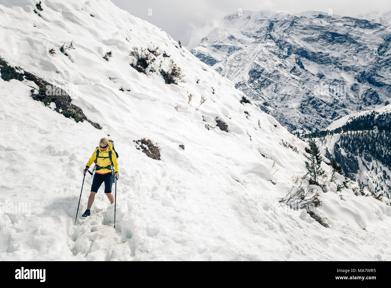 Frau Wanderer Trekking im Himalaya in Nepal. Wandern im Schnee weiß im Winter Natur, hohe Berge in Asien, schöne inspirierende Landschaft. Stockfoto