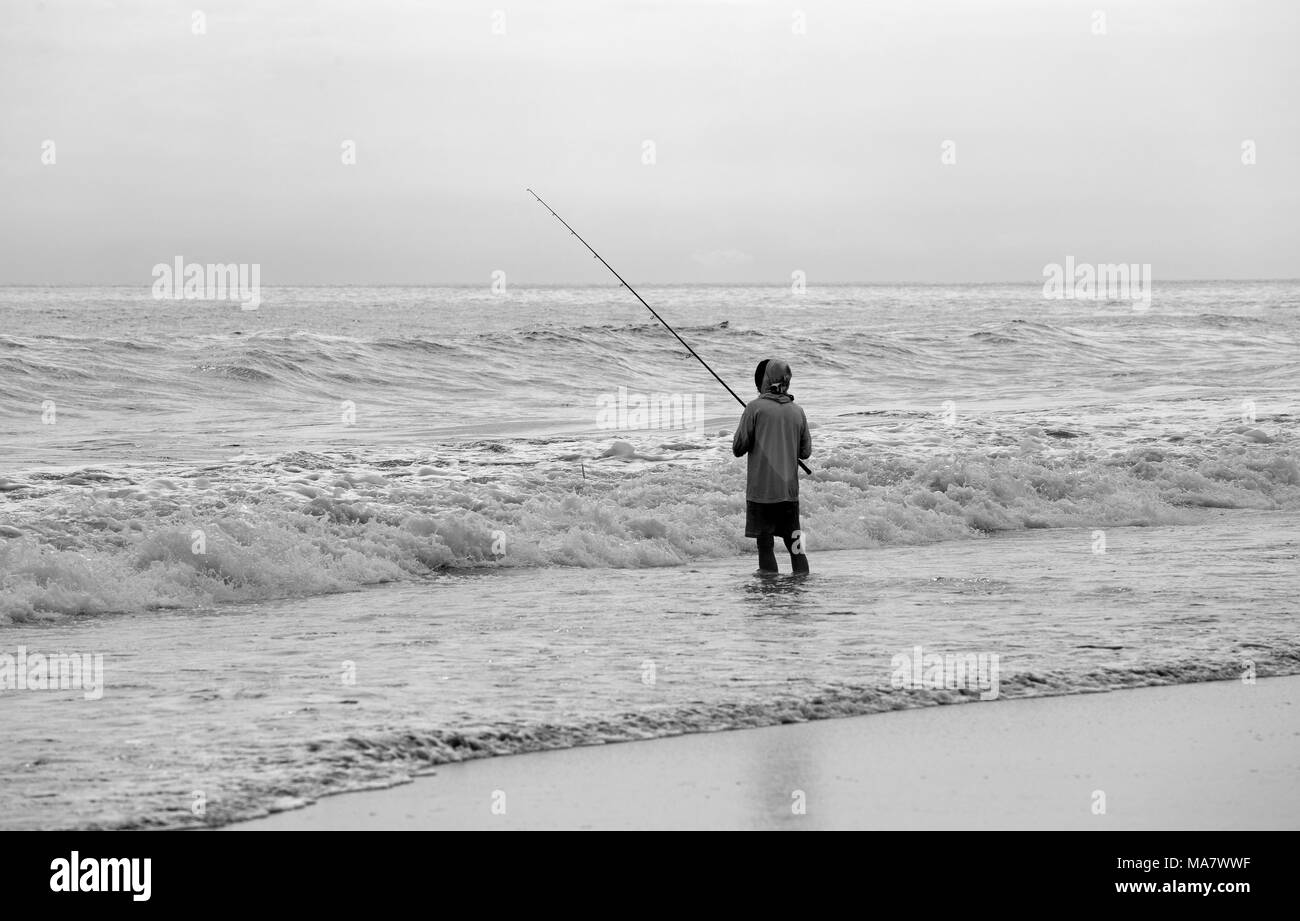 Mann angeln auf einem asiatischen Strand Stockfoto