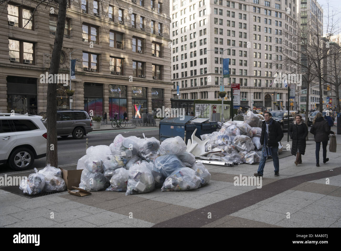 Klar eingesackt recyclingfähigen Müll auf der Straße bereit zur Abholung am Broadway von der Sehenswürdigkeit Flatiron Building. Manhattan hat praktisch keine Gassen, sodass die meisten Müll auf die Straße gesetzt. (Sehr unansehnlich) Stockfoto