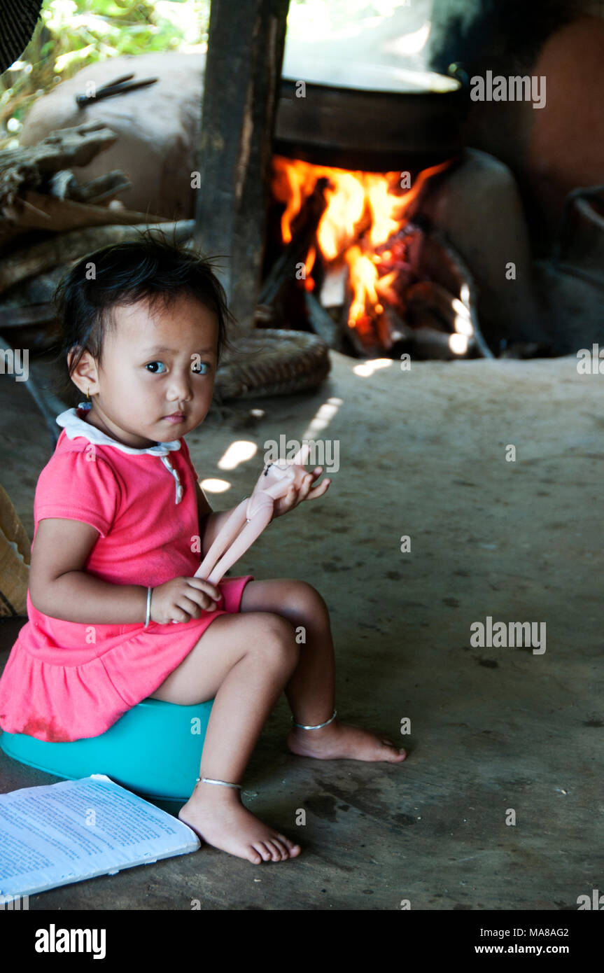 Nepal 2014. Pangma Dorf. Ein kleines Mädchen sitzt auf ihr Töpfchen mit einem gebrochenen Barbie-puppe. Stockfoto