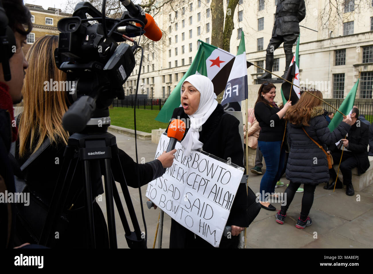 Syrische Demonstrant hält ein Schild lesen: "Wir hatten niemals die Bogen zu niemandem außer Allah, Assad sagte zu ihm: 'Während der syrischen Protest in London zu beugen, Großbritannien Stockfoto