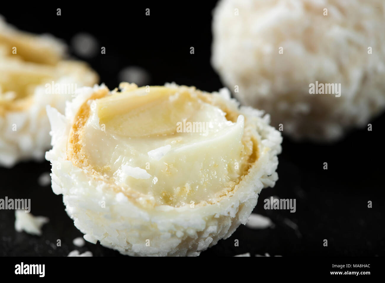 In der Nähe von Broken candy mit weißer Schokolade auf dunklem Schiefer Hintergrund Stockfoto