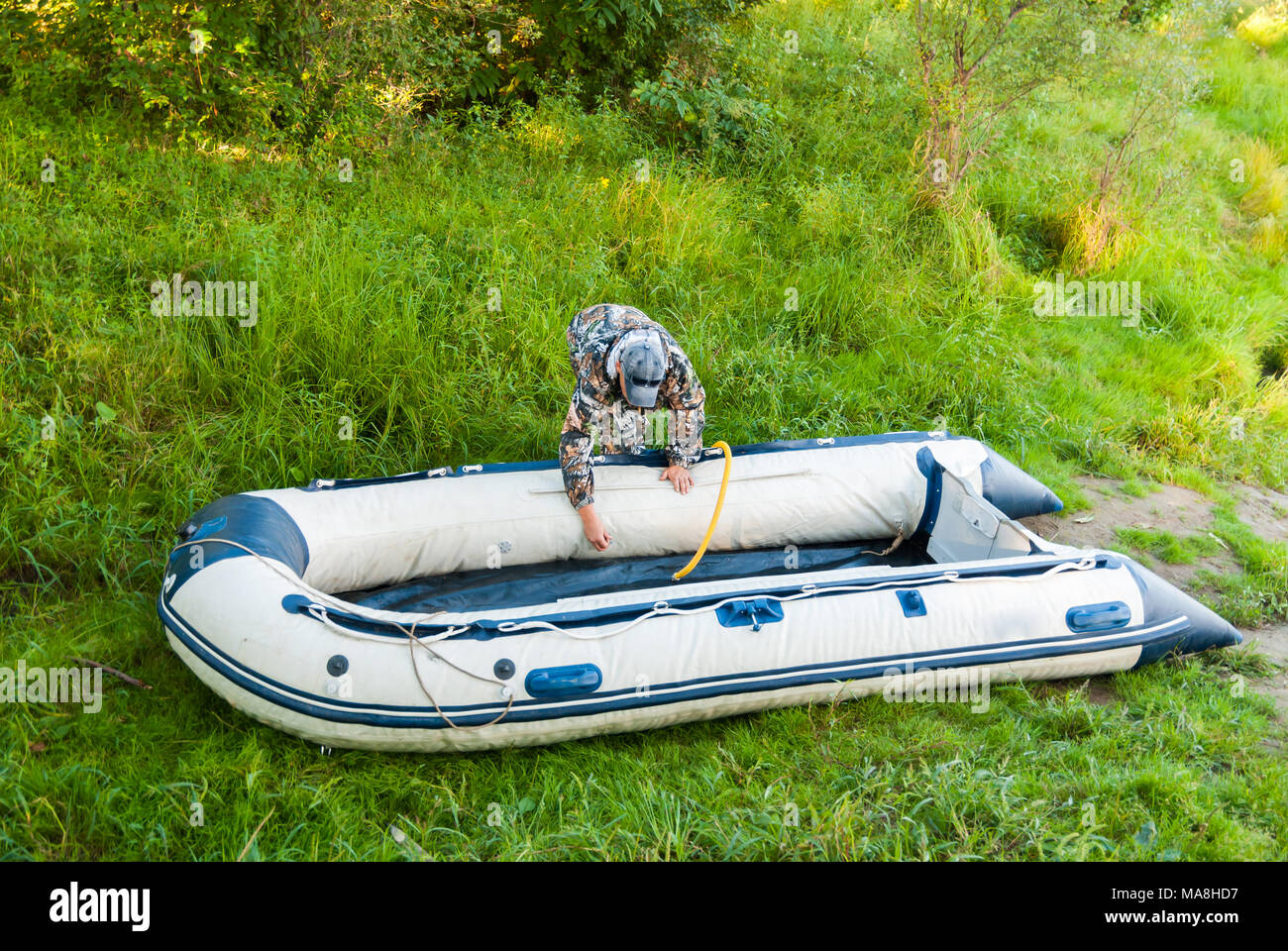 Man bereitet sich für Angeln, aufblasbares Schlauchboot Pumpe. Stockfoto