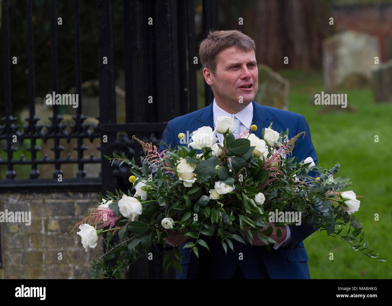 Mann verlassen Kirche Hochzeit mit einem Blumenarrangement Stockfoto
