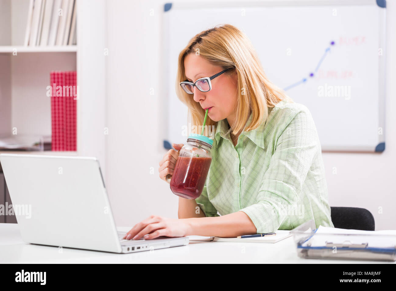 Geschäftsfrau ist Trink Smoothie in Ihrem Büro. Stockfoto