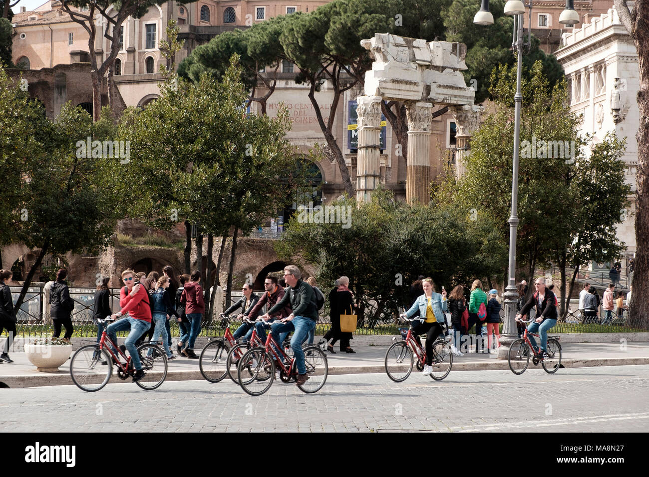 Das Forum Romanum und der Tempel der Venus Genetrix im Hintergrund einer Gruppe von Radfahrern auf die Via Dei Fori Imperiali, Rom Stockfoto