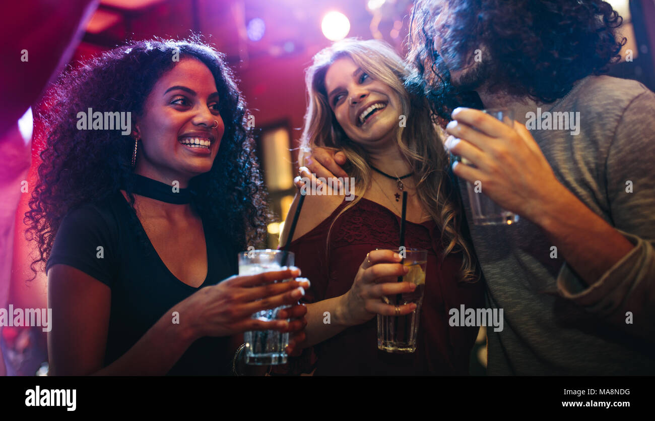 Glückliche junge Frauen feiern Freunde an der Bar. Eine Gruppe von Freunden eine gute Zeit im Nachtclub. Stockfoto