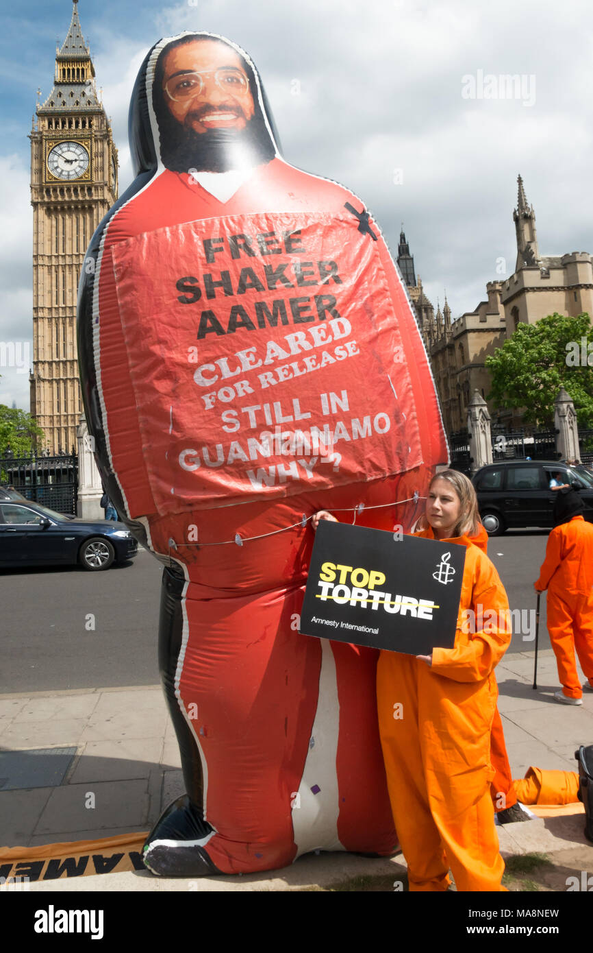 Tania Mathias, gewählt Letzten Monat als konservativ MP für Twickenham Posen mit einer Amnestie Poster top Folter" und einem riesigen aufblasbaren Shaker Aamer vor Big Ben. Stockfoto